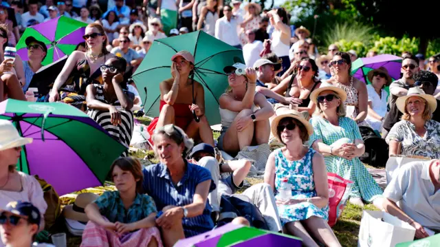 Fansd gather with umbrellas at Wimbledon