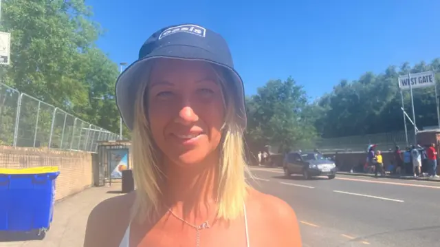 April Lipscomb is smiling at the camera and is wearing a black Oasis bucket hat.