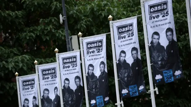 Flags advertising the Oasis concert in Heaton Park. They have a picture of Noel and Liam Gallagher and say Oasis live '25 at the top