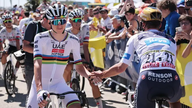 Tadej Pogacar shakes hands with Remco Evenepoel before stage seven of the 2025 Tour de France