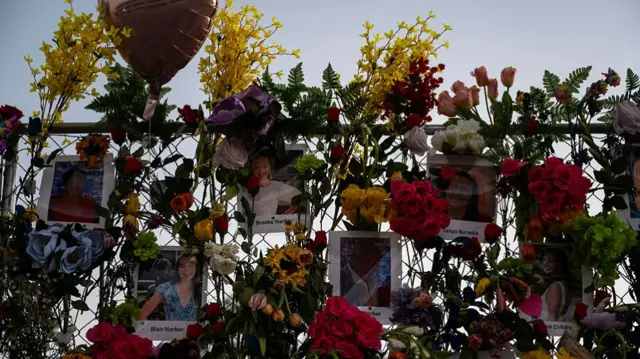 More photos and names strung along a wall of flowers
