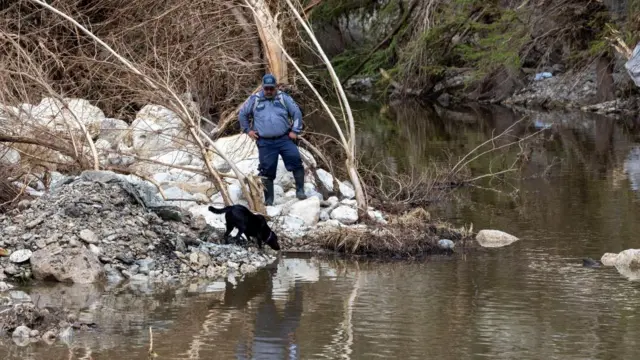 A member of a search and rescue team and his dog look for missing people