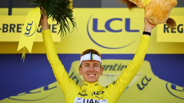 Tadej Pogacar with his arms aloft on the podium after winning stage seven of the 2025 Tour de France