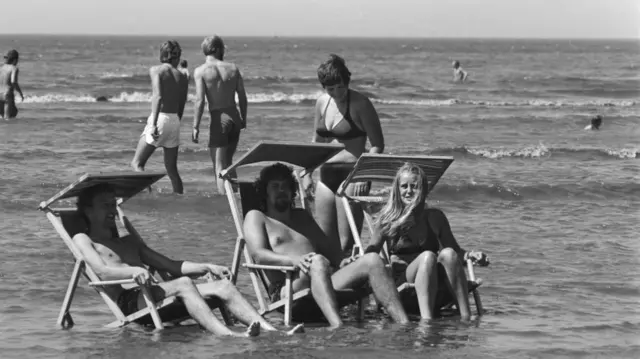 People in the sea in deckchairs in 1976
