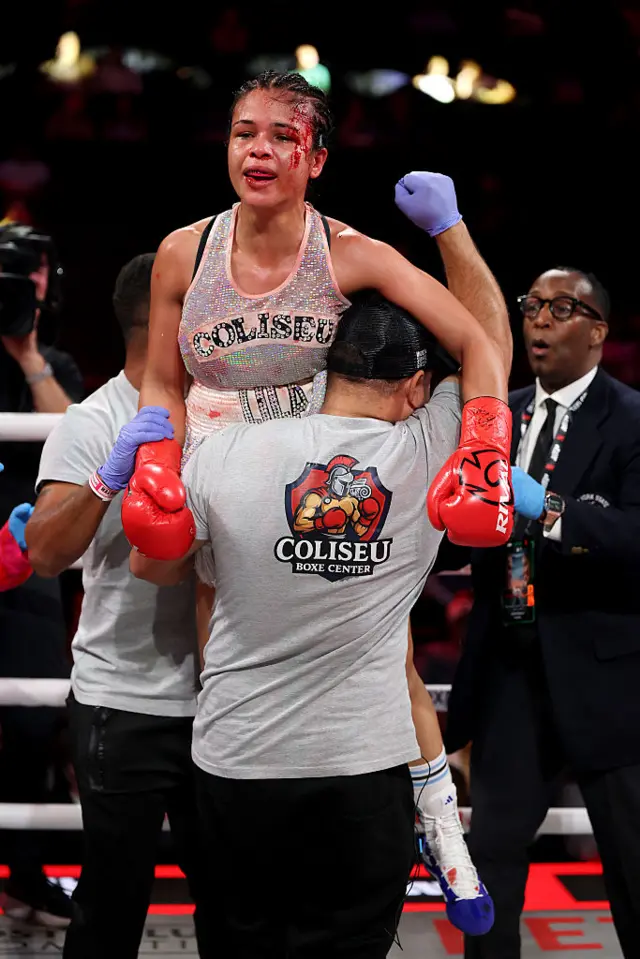 A bloodied Lila Furtado is lifted up by her team