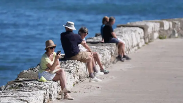 People on the pier enjoying the hot weather in Carrickfergus, Northern Ireland