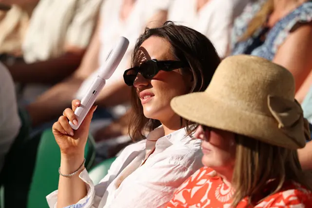 A spectator fans themselves on day eleven of The Championships Wimbledon 2025 at All England Lawn Tennis and Croquet Club on July 10, 2025 in London, England.