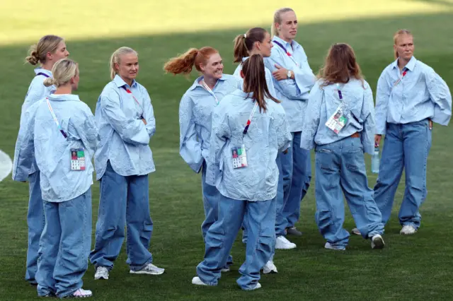 Denmark players stand in their sky blue blouses and jeans