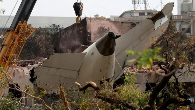 A crane removes the wreckage of the Air India Boeing 787-8 Dreamliner aircraft.
