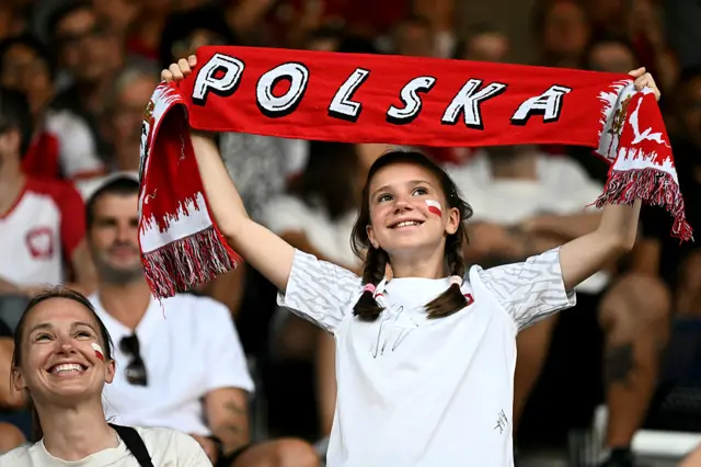 Poland fan holds up a scarf in the stands
