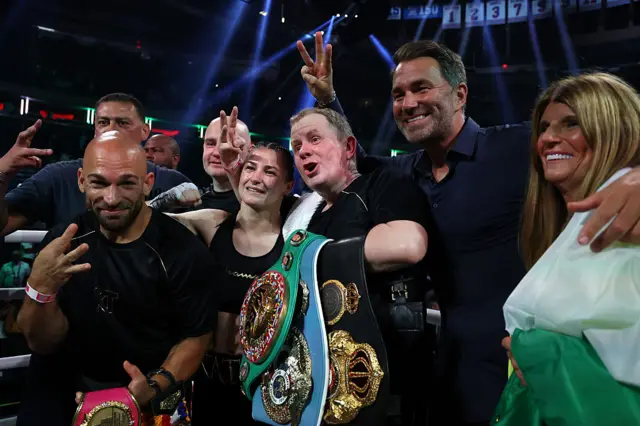 Katie Taylor posing for pictures with her team and world titles