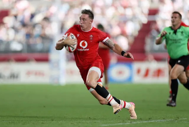 Wales wing Josh Adams runs with the ball