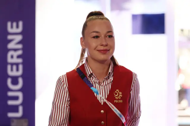 Poland player arrives in red suit, waistcoat and red and white striped shirt