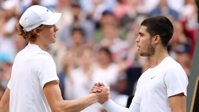 Jannik Sinner and Carlos Alcaraz shake hands at Wimbledon in 2022