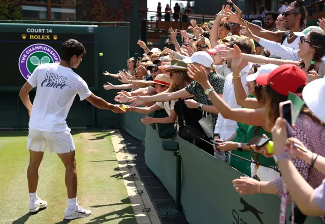 Carlos Alcaraz with fans on court 14 Wimbledon
