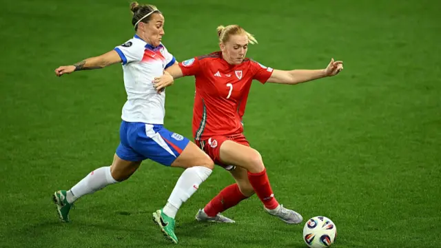 Ceri Holland of Wales is challenged by Lucy Bronze of England