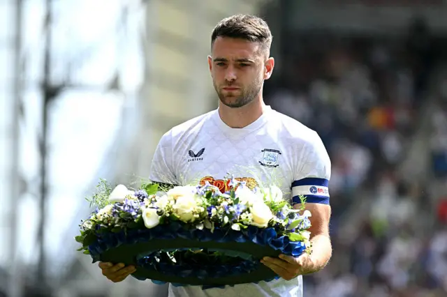 Ben Whiteman with a wreath in tribute to Diogo Jota