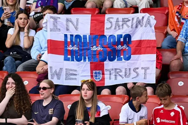 England fans gather in the stand holding a St George flag saying 'In Sarina we trust'