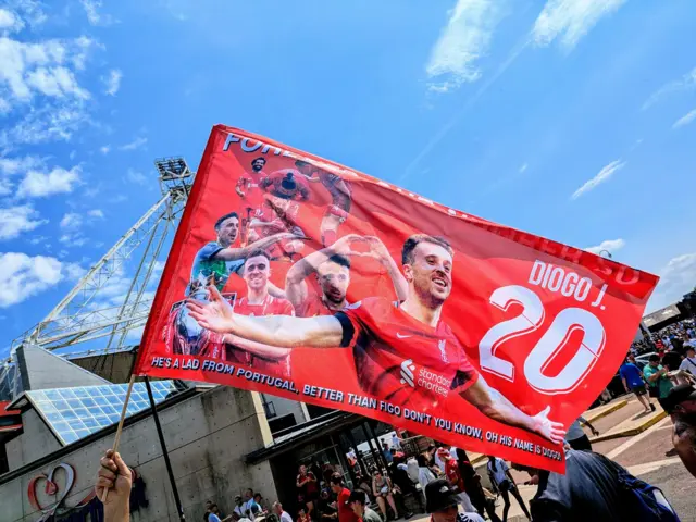 Liverpool fans with a flag commemorating Diogo Jota