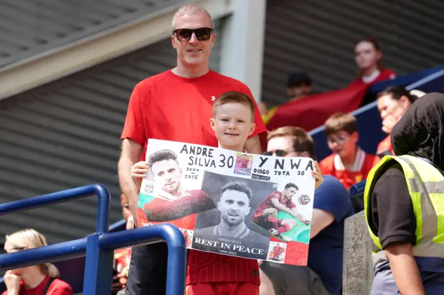 A young Liverpool fan holding a banner in tribute of Liverpool player Diogo Jota ahead of the pre-season friendly match at Deepdale Stadium, Preston.