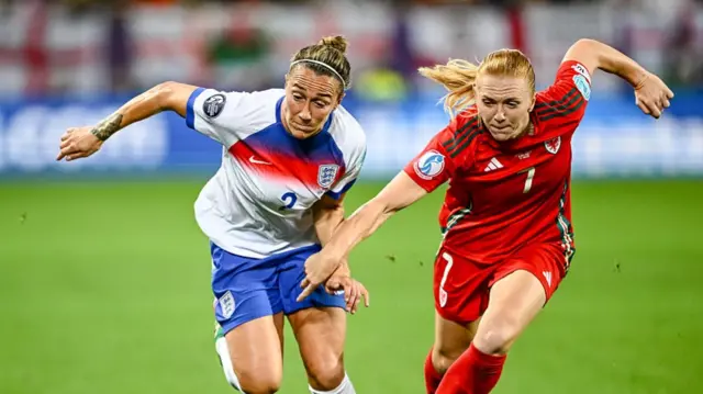 Bronze of England and Ceri Holland of Wales battle for the ball