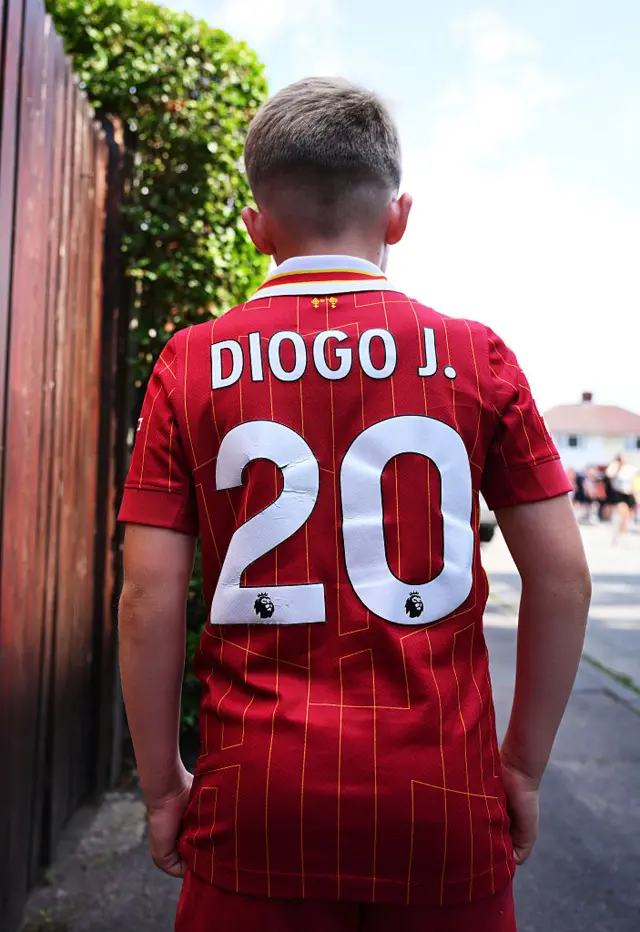 Liverpool fan wearing shirts with Diogo J. 20 on the back