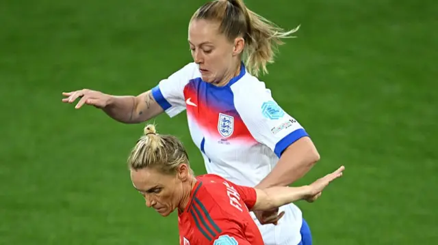 Jess Fishlock of Wales runs with the ball whilst under pressure from Keira Walsh