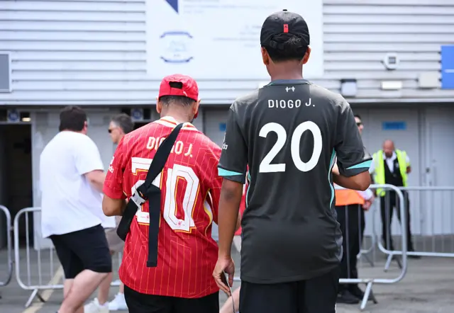 Liverpool fans wearing shirts with Diogo J. 20 on the back
