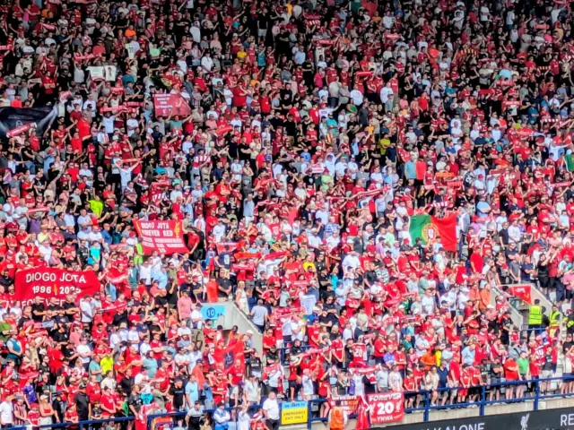 Liverpool fans hold flags bearing Diogo Jota's name