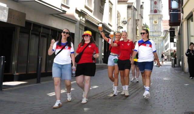 England and Wales fans walk in the streets of St. Gallen with the Cathedral in the background