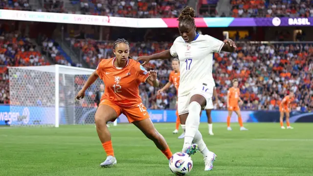 Sandy Baltimore of France runs with the ball under pressure from Chasity Grant of the Netherlands