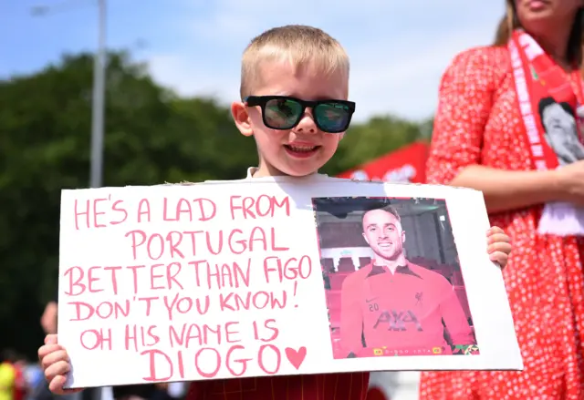 A Liverpool fan with a poster in honour of Diogo Jota