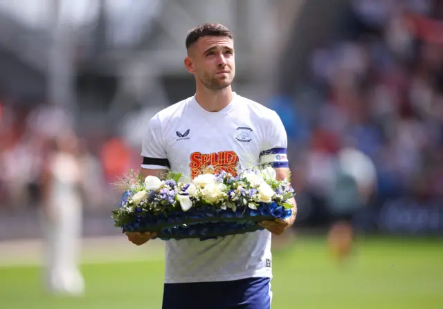 Preston North End's Benjamin Whiteman with a wreath of flowers in tribute to Liverpool's Diogo Jota before the match