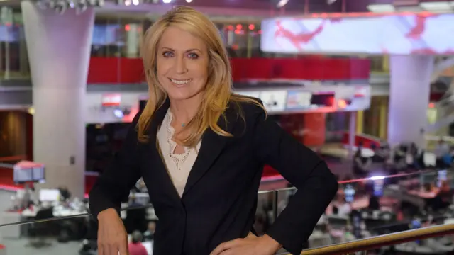Deborah Turness inside Broadcasting House with the newsroom in background