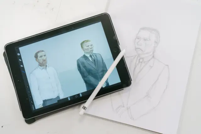 A tablet with a sketch of Graham and Carruthers across which a white pencil has been laid. Next to it is a pencil sketch of Carruthers on a piece of paper.