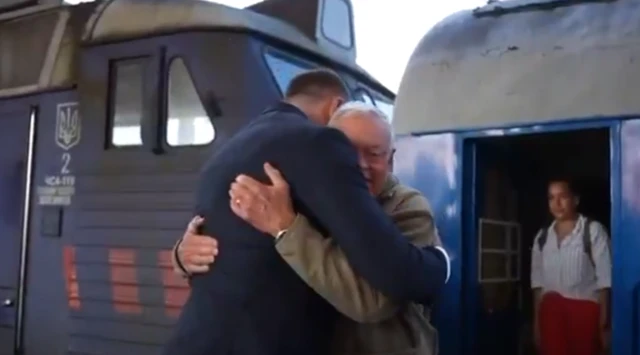 Keith Kellogg is greeted by Andriy Yermak outside a blue train which has just pulled into a station in Kyiv