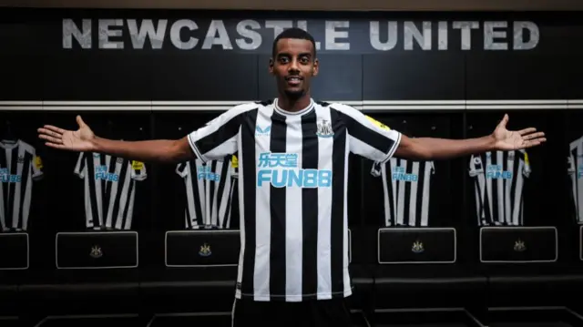 Alexander Isak poses for photos after signing for Newcastle