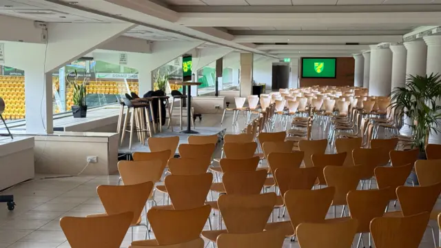 Rows of empty seats are pointed towards the main stage ahead of the start of a question and answer event in a football stadium's lounge