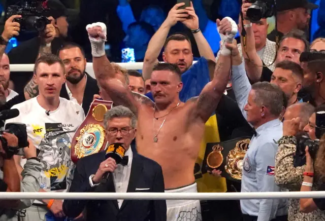 Oleksandr Usyk holding his hands in the air after beating Daniel Dubois