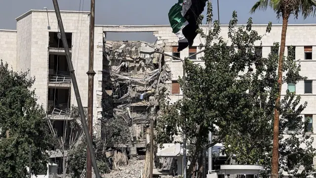 A buildings exterior, the middle of it is completely ruined and falling down where it has been struck