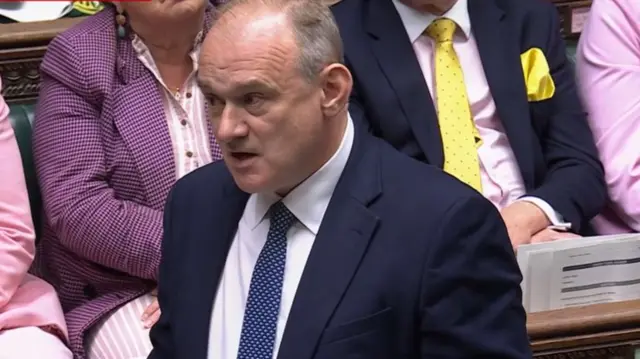 Ed Davey wearing a dark suit and tie and a light shirt