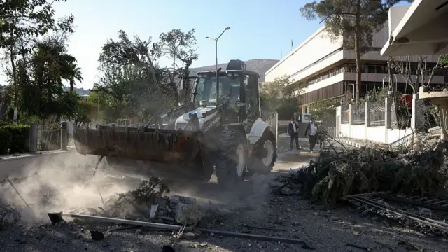 Digger removing rubble near Syrian defence ministry