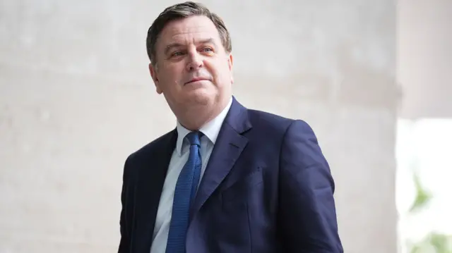 Mel Stride, who has short combed greying brown hair, wearing a navy suit outside the BBC building