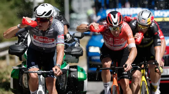 Mathieu van der Poel and Axel Laurance take a drink during stage 11 of the 2025 Tour de France