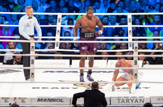 Daniel Dubois standing over Oleksandr Usyk