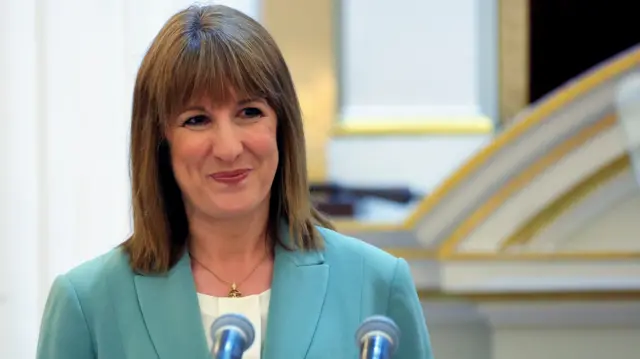 Rachel Reeves, who has shoulder-length light brown hair with a fringe and wears a light green blazer, makes a speech in London