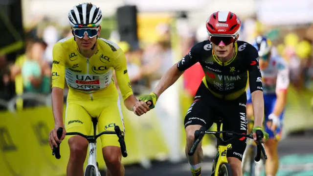 Tadej Pogacar and Jonas Vingegaard shake hands after crossing the finish line on stage 10 of the 2025 Tour de France
