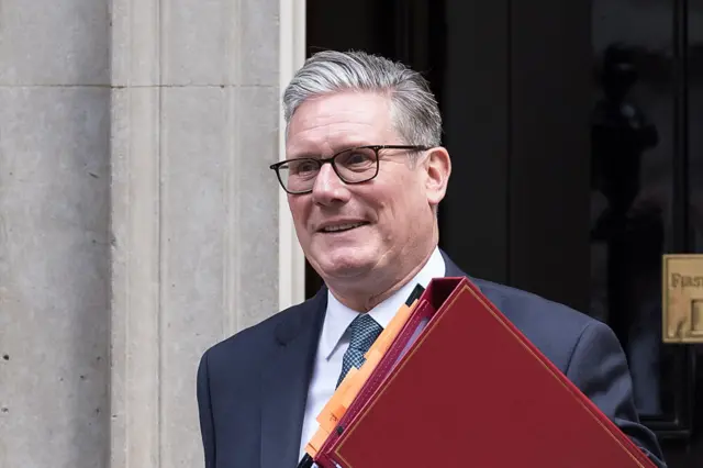 Keir Starmer holding a red folder as he leaves Downing Street