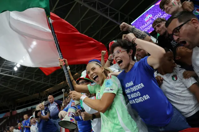 Italy's Eleonora Goldoni celebrates with a flag and fans after the match