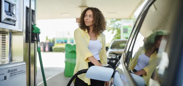 Woman filling up car with petrol - stock shot